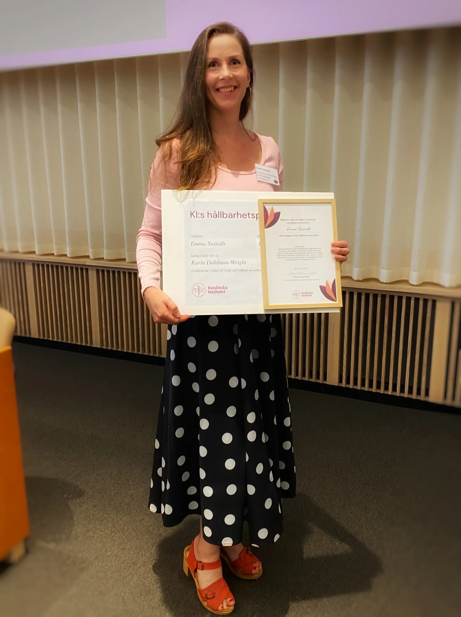 Kvinna håller upp "KIs hållbarhetspris".