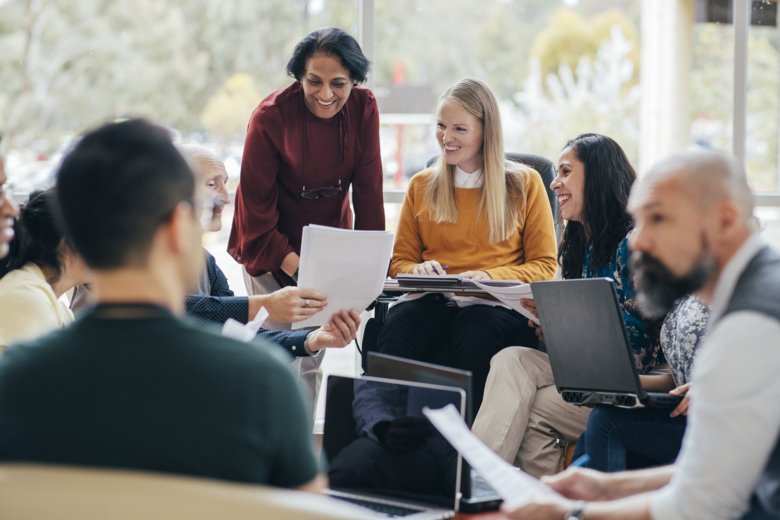 En grupp av studenter arbetar tillsammans med en lärare.