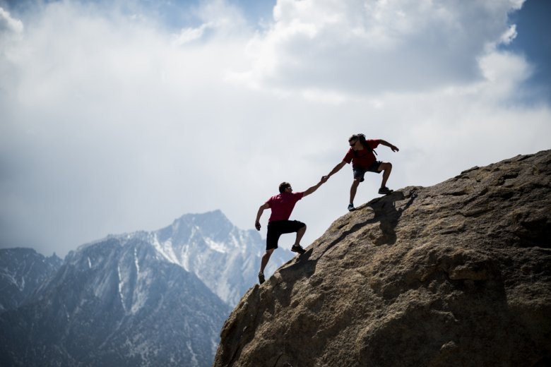 Bergsklättrare som hjälper varandra