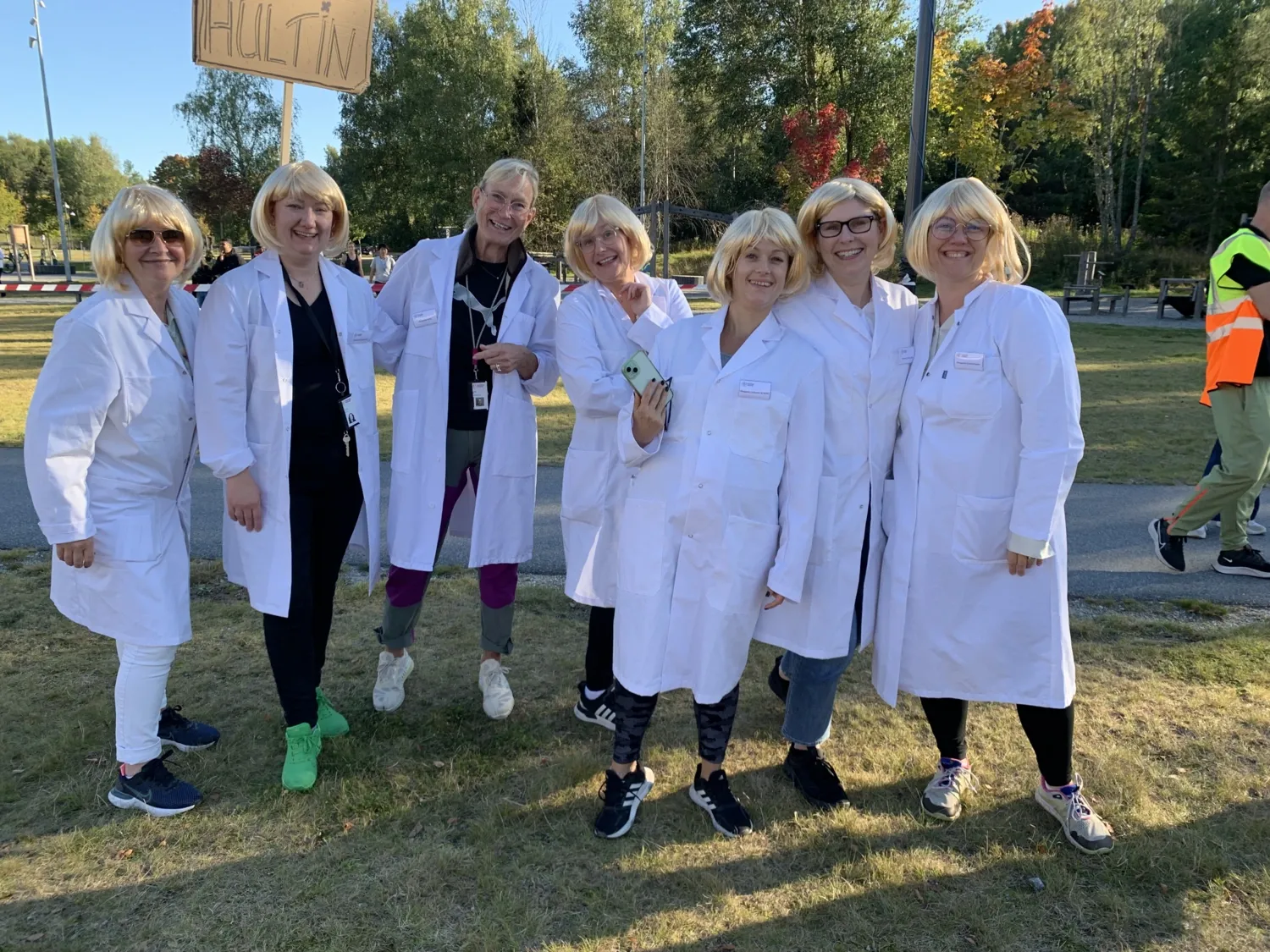 Lag Hultin är utklädda i vita lab rockar och samma blonda peruk