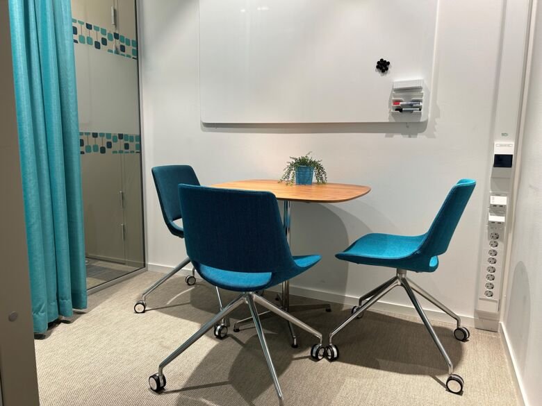 Foto på ett bord och tre stolar i ett samtalsrum i ANA Futura.
