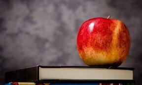 A red apple on top of a book