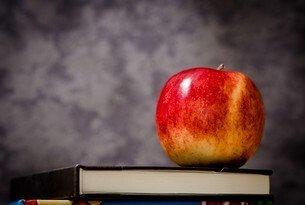 A red apple on top of a book