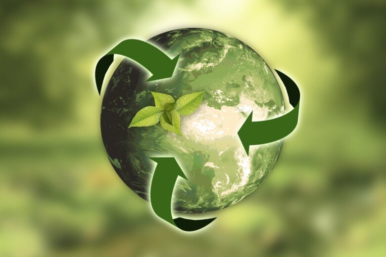 Fotokonst, jordglob med logo, pilar för återvinning runtomkring, hela bilden är i gröna nyanser.