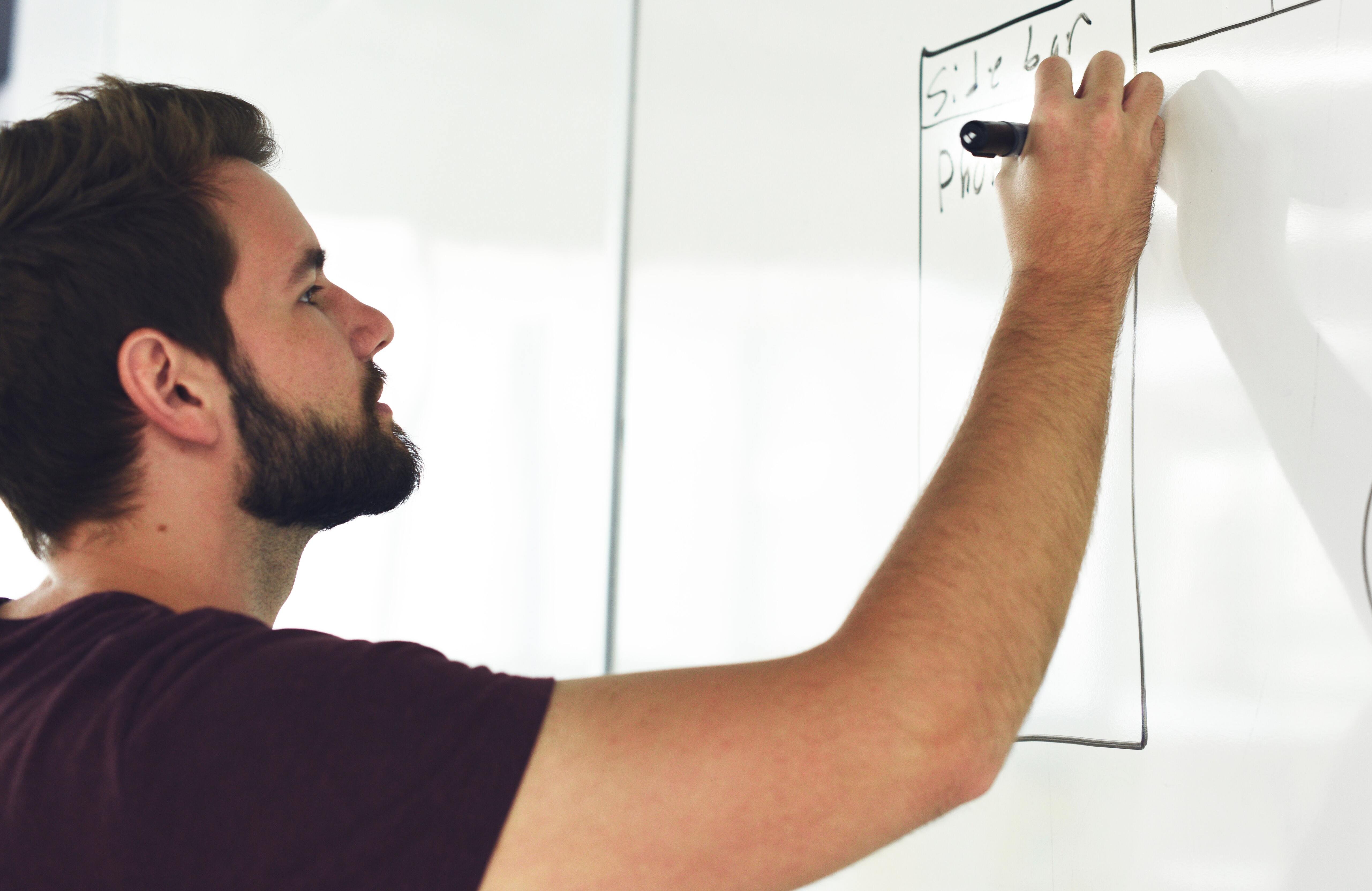 Man writing on a whiteboard.