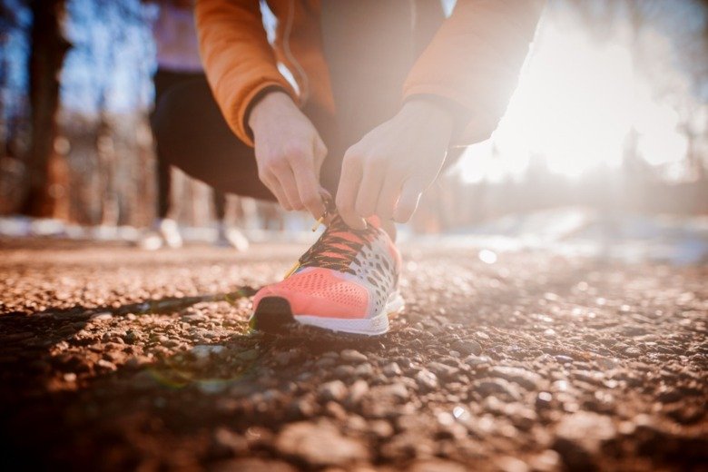 Woman adjusting her shoelaces before training.