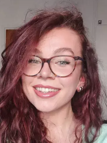 Profile picture: female, dark red hair, glasses