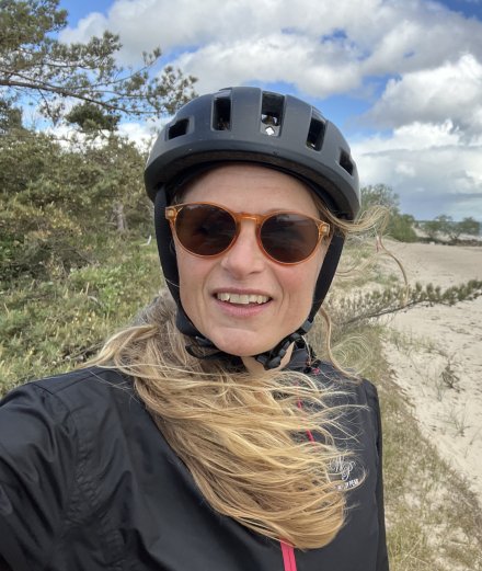Pernilla står vid en strand på Österlen och det ser ut att blåsa en del.